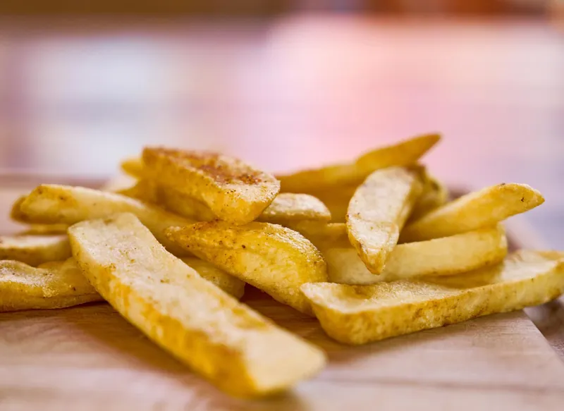 Dikke friet met de schil op een houten plank